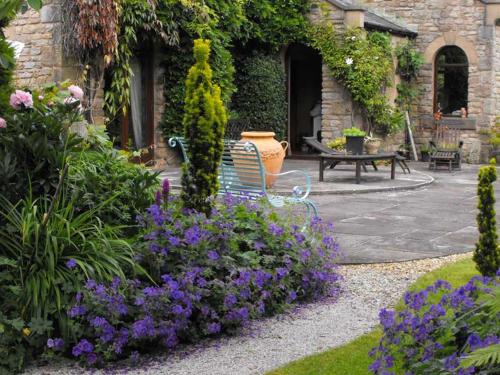 a bench sitting in a garden with purple flowers at Whitmore in Lancaster