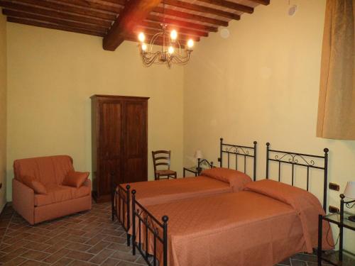 1 dormitorio con 1 cama y 1 silla en Agriturismo Collodi en Montalcino