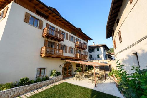an outdoor patio with tables and chairs and a building at Agritur La Pieve in Taio