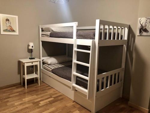 un letto a castello bianco in una stanza con un comodino di Acogedor apartamento en el corazón del Valle a Les Bordes