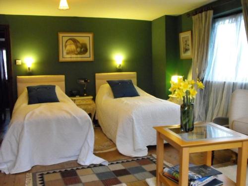 duas camas num quarto com paredes verdes em Whitmore em Lancaster