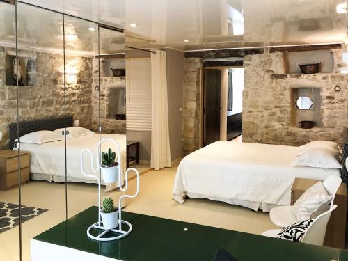 a bedroom with two beds and a glass wall at Villa Authentique et Architecturale - Centre Ville in Forcalquier