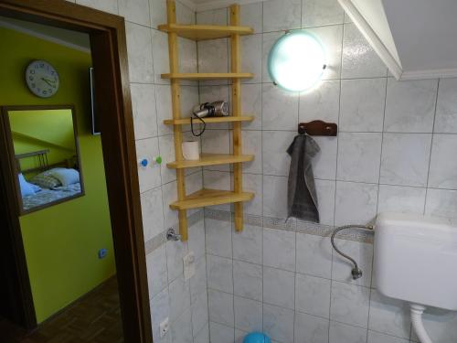 a bathroom with wooden shelves on the wall at Sobe-Apartma in Maribor