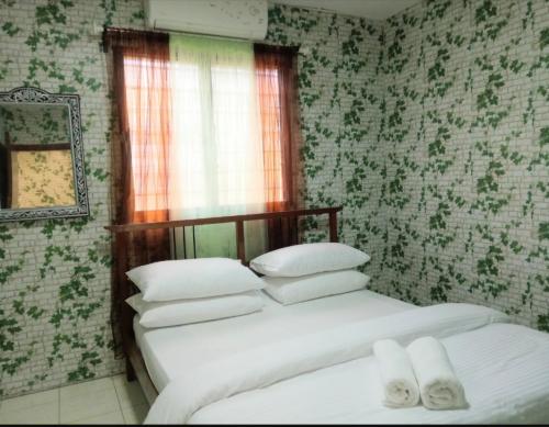 2 camas en un dormitorio con papel pintado verde y blanco en 2 BR Medina Dollar Landed Homestay Cheras MRT Link, en Cheras