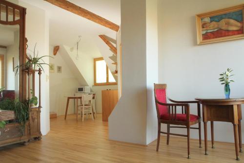 salon ze stołem, krzesłami i schodami w obiekcie Apartmán Nella w mieście Valtice