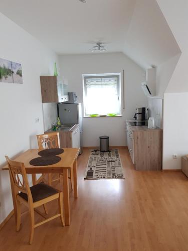 cocina y comedor con mesa y sillas en Romantik Ferienwohnung am Tor zum Allgäu - Erwachsenenferienwohnung, en Fuchstal