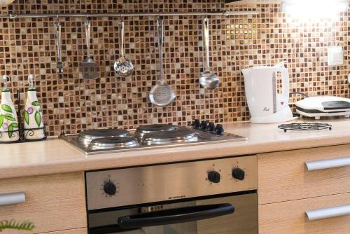 a kitchen with a stove and utensils on the wall at Cosy House in Palekastron
