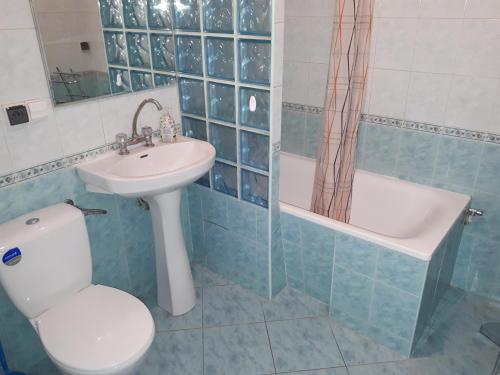 a bathroom with a toilet and a sink and a tub at Mieszkanie 3-pokojowe Gdańsk, ul. Rybna (2/4 piętro) in Gdańsk