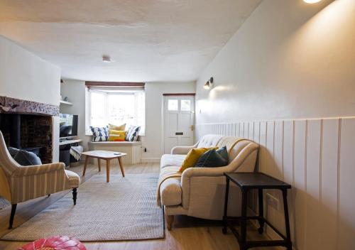 a living room with a couch and a chair at Goose Cottage in Marlborough