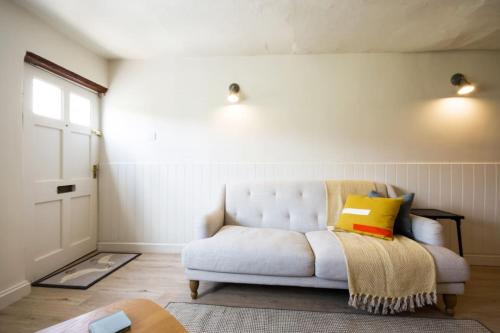 a living room with a white couch and a window at Goose Cottage in Marlborough