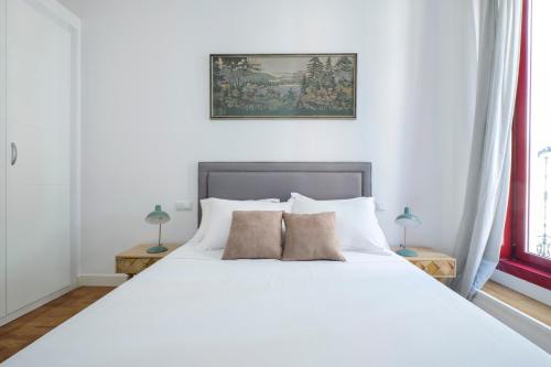 una camera da letto con un grande letto bianco con due cuscini di Fuencarral Boutique a Madrid