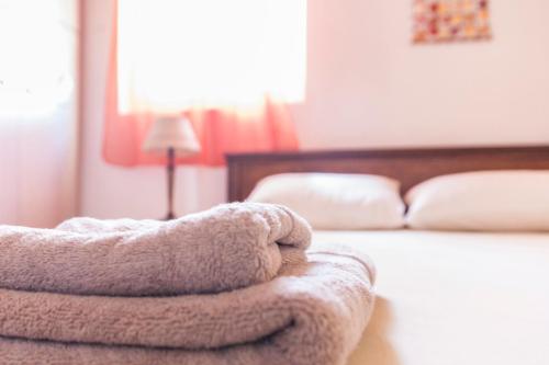 a pile of towels sitting on the edge of a bed at Attic Anemoessa in Alexandroupoli