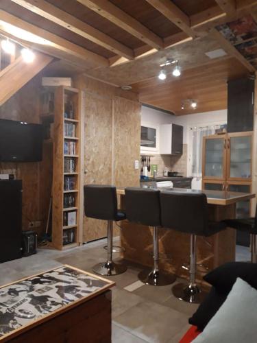 a kitchen with a table and chairs in a room at Home for Geeks in Le Bélieu