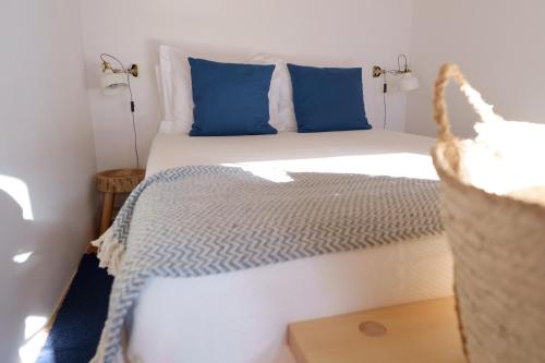 um quarto com uma cama com almofadas azuis em Casas de Mértola 32 em Mértola
