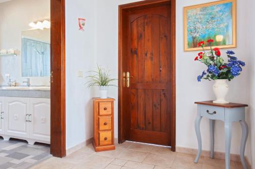 a bathroom with a door and a vase of flowers on a table at Villa Dune in La Asomada
