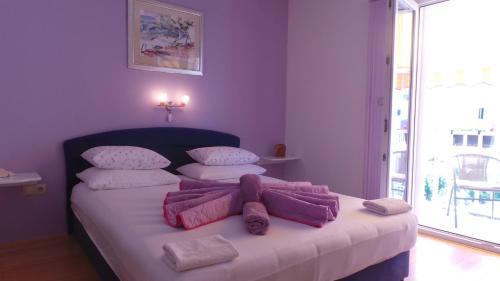 Un dormitorio con una cama con sábanas y almohadas púrpuras. en Villa Vera en Hvar