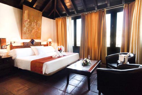 1 dormitorio con 1 cama, escritorio y mesa sidx sidx sidx sidx en Casa Palacio Pilar del Toro, en Granada