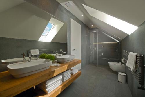 a bathroom with two sinks and a toilet at Vila Ula La Luxury Apartments in Bled