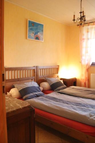 2 camas individuales en un dormitorio con ventana en A l'Ancienne Ferme, en Sarre-Union