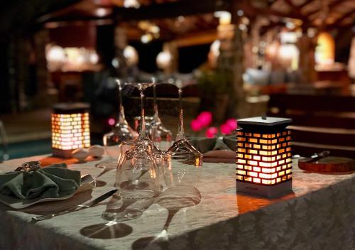 a table with wine glasses and lights on it at Château de feuilles & SPA - Praslin island in Baie Sainte Anne