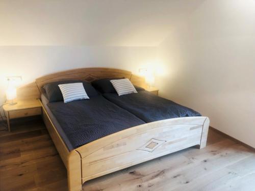 a bedroom with a large wooden bed with two pillows at Feielhof in Krakaudorf
