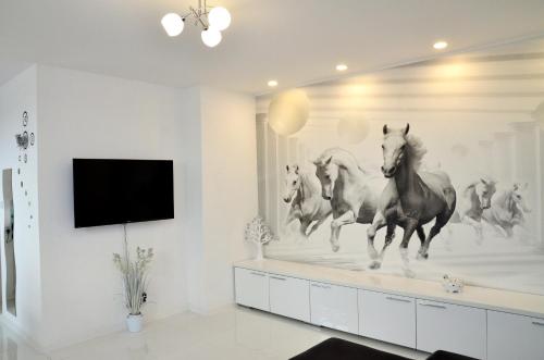 a living room with a wall mural of horses running at Apartament Domi in Gniezno