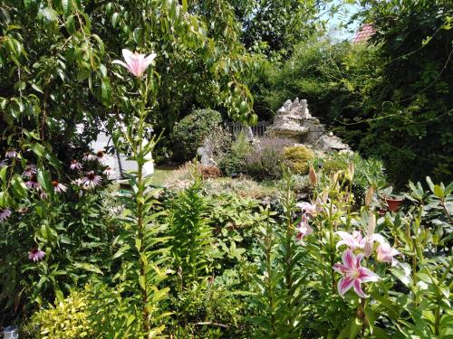 a garden with pink flowers and a stone structure at VILLA GUT in Bolesławiec