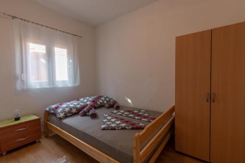 ein Schlafzimmer mit einem Bett, einer Kommode und einem Fenster in der Unterkunft Apartman Kristo in Vir