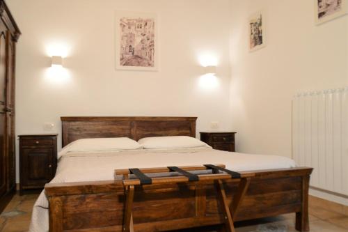 a bedroom with a wooden bed and two lights on the wall at Il Castello in Petralia Sottana