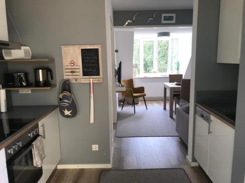 eine Küche mit einer Tür, die zu einem Esszimmer führt in der Unterkunft Kajüte Holtenau in Kiel
