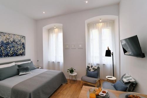 a bedroom with a bed and a living room at Vitopolis 1&2 in Rijeka