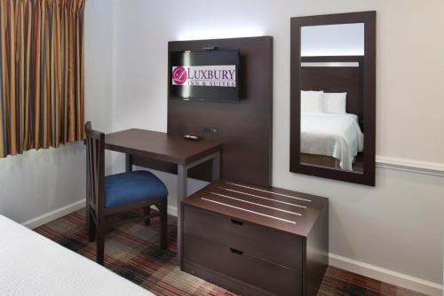 Postel nebo postele na pokoji v ubytování Luxbury Inn & Suites
