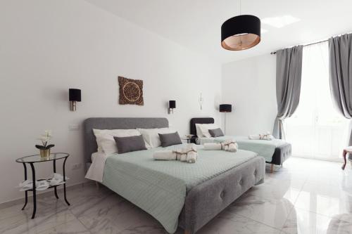 2 camas en un dormitorio con paredes blancas en Calafatari B&B en Siracusa