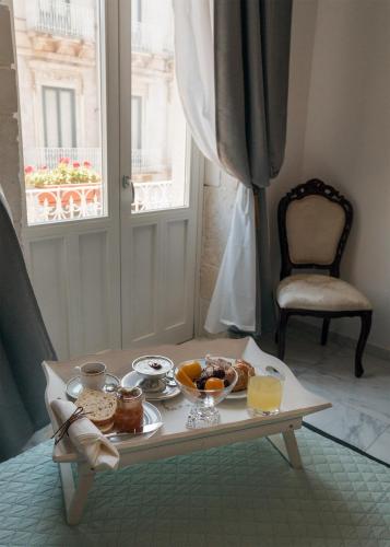 un vassoio di cibo su un tavolo in una stanza con finestra di Calafatari B&B a Siracusa
