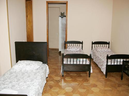 a room with three beds in a room at Two Towers Guest House in Kutaisi