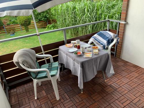 einen Tisch und Stühle auf einem Balkon mit Sonnenschirm in der Unterkunft Ferienwohnung Holstenstern in Kellenhusen