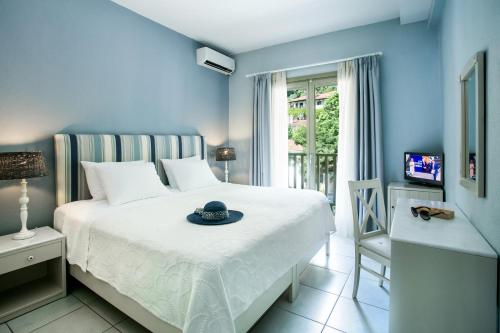 a bedroom with a bed with a hat on it at Kenta Beach Hotel in Agios Ioannis Pelio