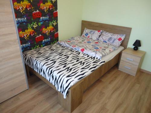 a bed in a room with a zebra print wall at Legyél a vendégünk :) in Debrecen