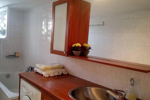 ein Badezimmer mit einem Waschbecken, einem Spiegel und einer Badewanne in der Unterkunft Comfy central flat in Thessaloniki
