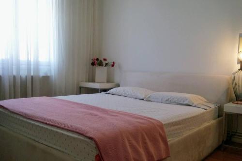 um quarto com uma cama com um cobertor vermelho em Comfy central flat em Tessalônica