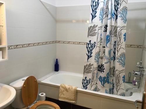 y baño con bañera, aseo y lavamanos. en Karpathos Guest House, en Menetaí