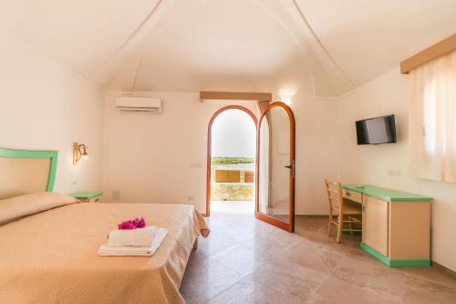 una camera con letto, scrivania e TV di Casa Zita Lampedusa a Lampedusa