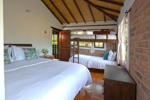 1 Schlafzimmer mit 2 Etagenbetten und Ziegelwand in der Unterkunft Casa de las Palmas in Villa de Leyva