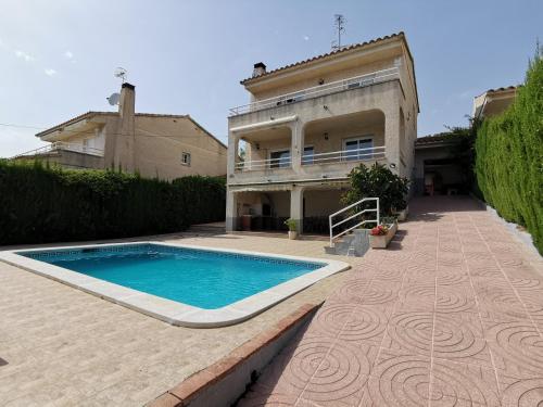 uma casa com uma piscina em frente em Villa Vista em Segur de Calafell