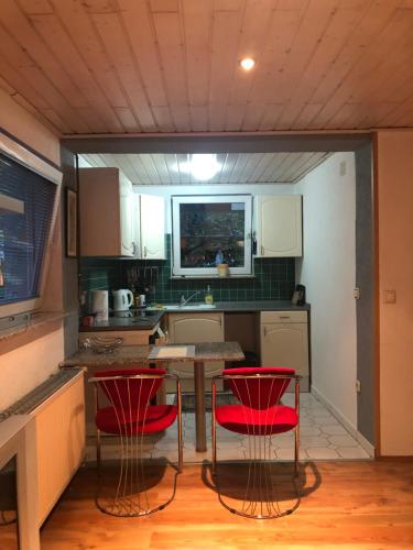 a kitchen with two red chairs and a table at Hava 2 in Sarajevo