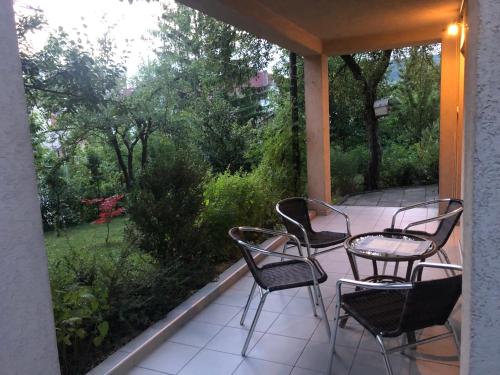 a patio with four chairs and a table on a porch at Hava 2 in Sarajevo