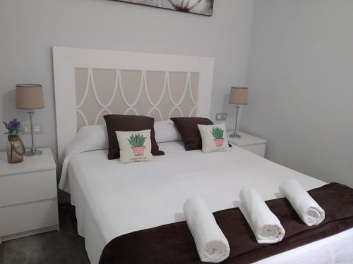 a white bedroom with a large white bed with two pillows at Los Nidos Sea Pretty&Beach- La Carihuela in Torremolinos