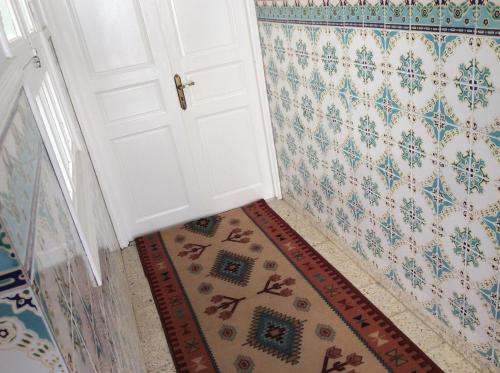 a white door in a hallway with a rug at Mouhib Sidi Bou Saïd House in Sidi Bou Saïd