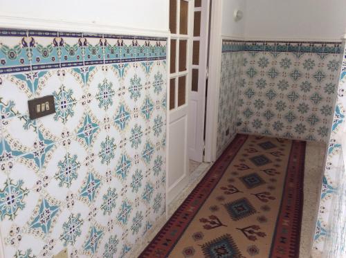 a hallway with blue and white wallpaper and a door at Mouhib Sidi Bou Saïd House in Sidi Bou Saïd