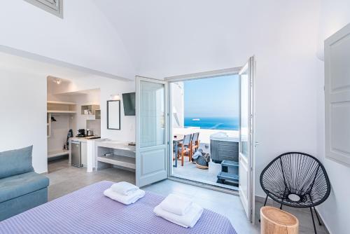 a living room with a blue couch and a view of the ocean at Caldera Stories private suites in Megalokhori